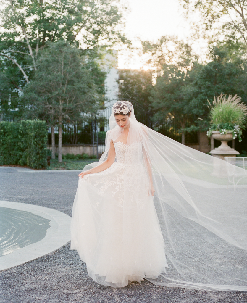 Mira Zwillinger’s “Charlie” A-line tulle silk gown with appliqués from Betty Bridal Atelier. Untamed Petals’ “Berlin” Juliet cap veil with beading from Lovely. Kendra Scott’s “Abigail” platinum bracelet from Kiawah Fine Jewelry. (Photo by Corbin Gurkin)