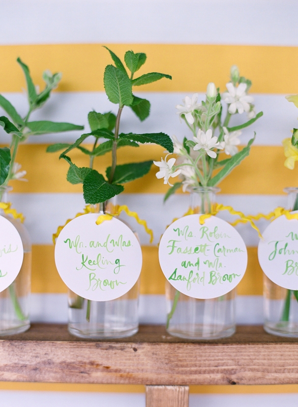 Guests received table assignments via petite bud vases.