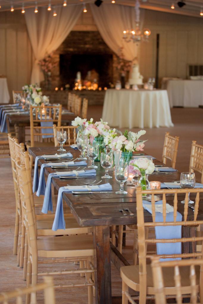 YOUR TABLE AWAITS: White, pink, and green arrangements and baby blue linens from BBJ Linens softened the rustic charm of the reception&#039;s wood-finished Chiavari chairs and wooden tables from Event DRS.