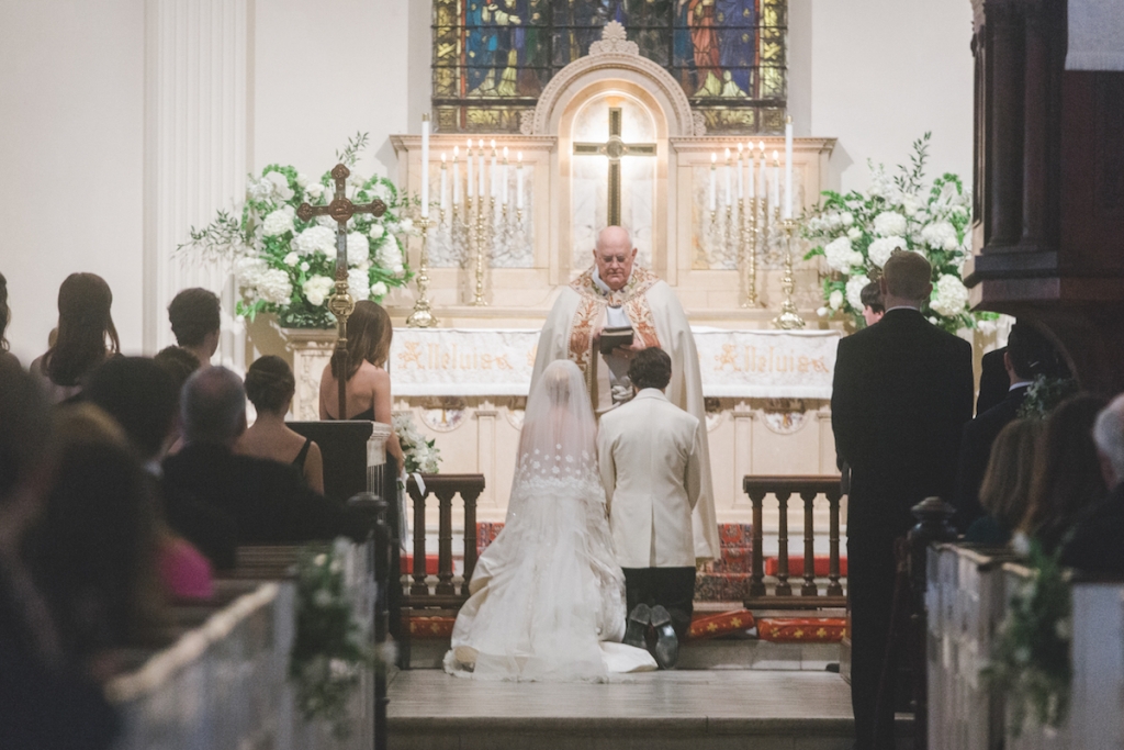 Bride&#039;s gown and veil by Oscar de la Renta. Menswear by Grady Ervin &amp; Co. Florals by Gathering Floral + Event Design. Image by Elisabeth Millay Photography at St. Philips Church.