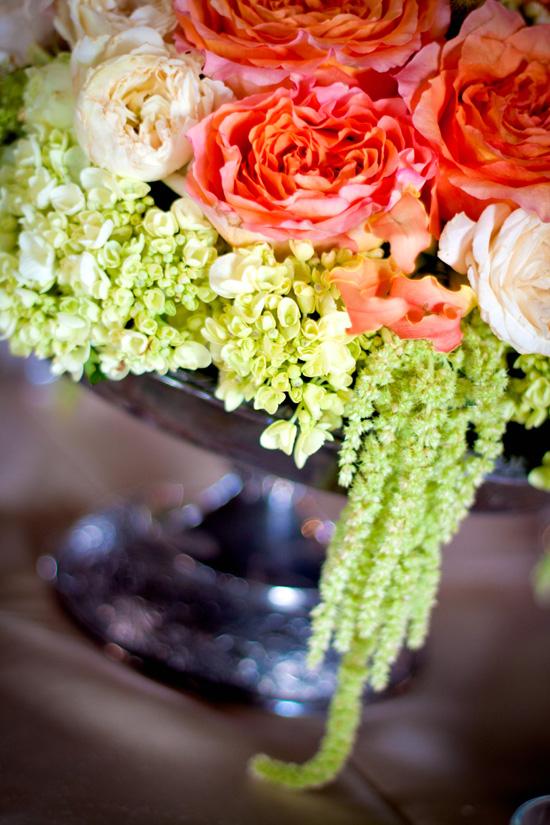 CASCADING CUTIES: Old-fashioned antique roses, green hydrangea, and strands of amaranthus green tails added pale-hued texture to the reception décor; the tarnished silver bowl lent an antique touch to the arrangement.
