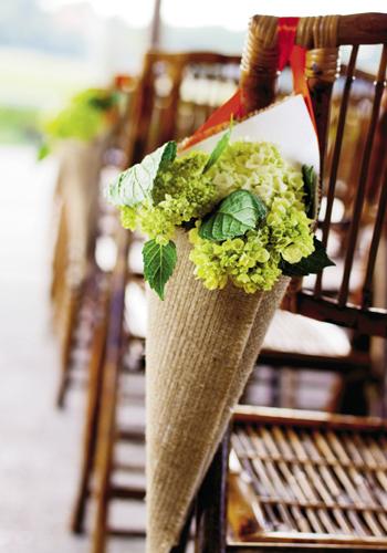 NATURAL NOTES: Pale green hydrangeas tucked into taupe woven cones hung along the aisle.