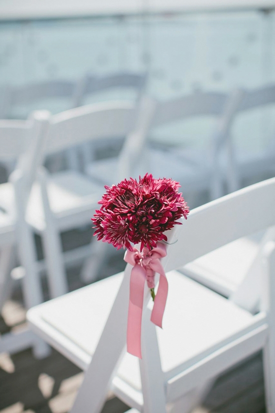PRETTY IN PINK: Magenta mums tied with light pink ribbons added a splash of color along the aisle.