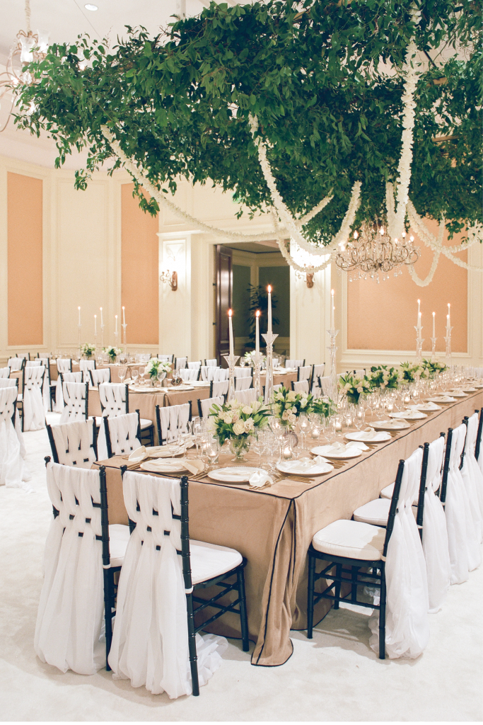 Guests dined under a verdant installation of lush greens and garlands of hand-strung orchids. Chiavari chairs swagged with gauzy fabrics (a signature Tara move), slender crystal candlesticks of varying heights, and custom-made ebony-piped table linens completed the opulent setting.   &lt;i&gt;Photograph by Corbin Gurkin&lt;/i&gt;