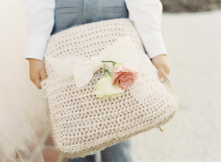 PILLOW TALK: Crystal crocheted the cover for the ring bearer&#039;s cushion and tied a pair of roses on top with sheer ribbon.