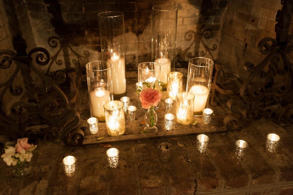 STATE OF GRACE: Mercury glass votive candles, cylinder glass candleholders, and petite flower vases brought elegance to the rural fireplace.