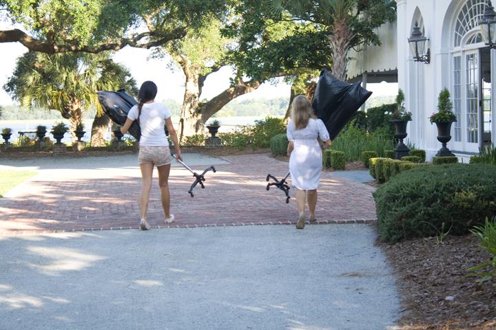 Style intern Kristy Lui and Charleston Weddings Editorial Assistant Molly Hutter carry gowns and mannequins (on loan from LulaKate) into the house at Lowndes Grove Plantation