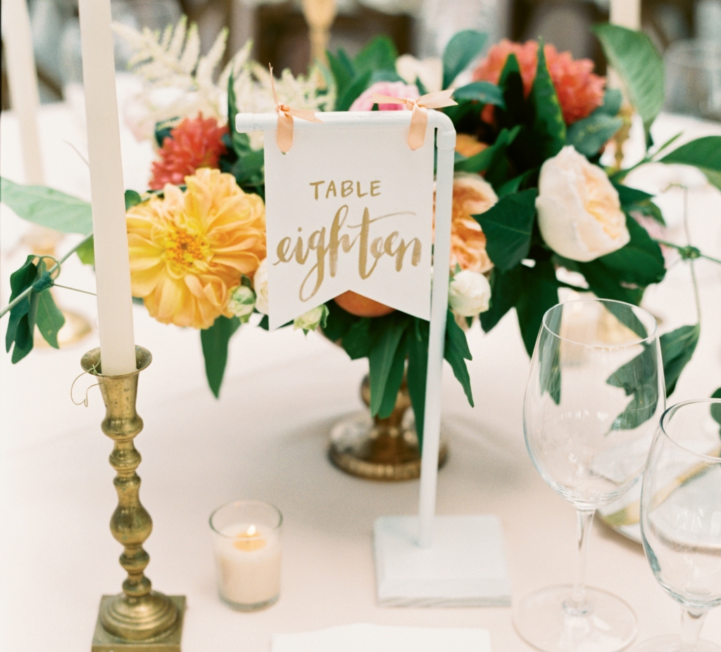 Sweet, simple details like these tables marked with pennants, peaches tucked into floral arrangements, and homey brass candlesticks can make a standout statement.