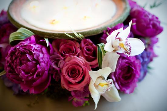 FIERY FLORA: Fuchsia peonies, pink roses, orchids, and green grasses framed neutral-colored candles to create vibrant centerpieces.