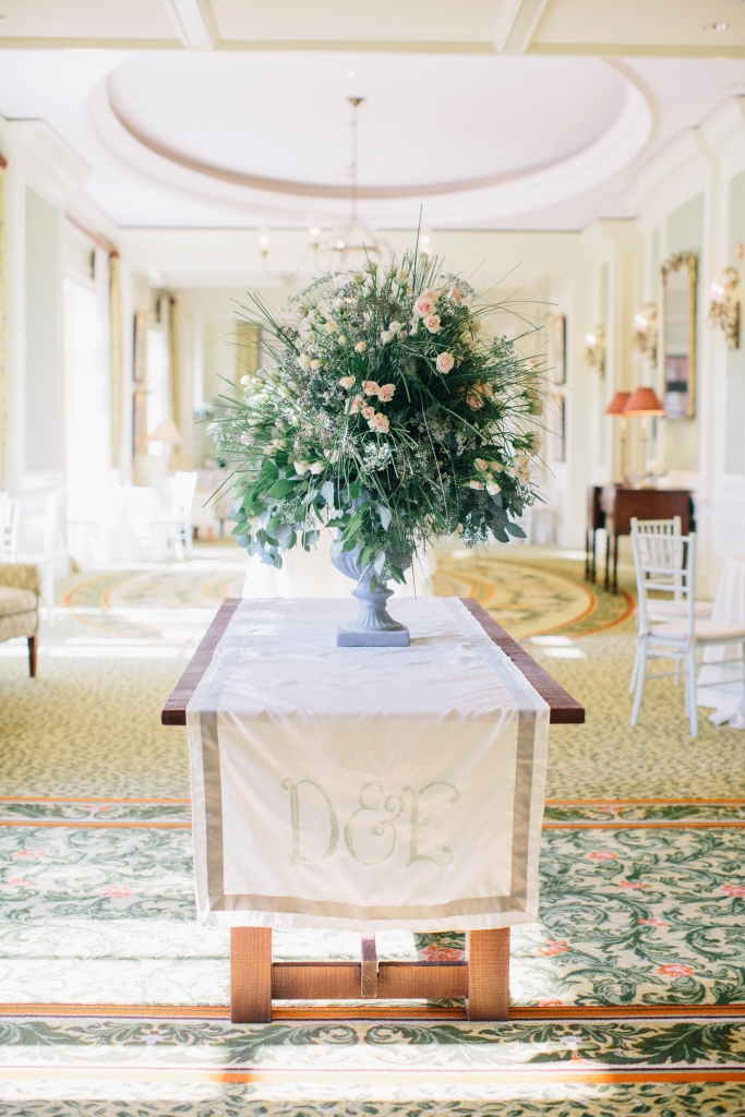 FLOWER TOWER: Welcoming guests to the reception was a monogrammed runner and a larger-than-life arrangement of hydrangeas, dusty miller, and bear grass