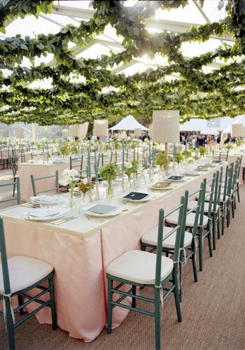Up on High: To keep the reception from being overly formal-and to make it seem like guests were dining outside- the team at Tara Guerard Soiree covered the tent&#039;s clear ceiling in swaths of lemon leaf garland.