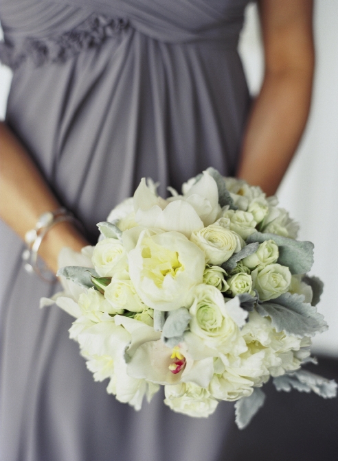 QUITE THE HANDFUL: Bridesmaids carried white ranunculus, cream-colored spray roses, and ivory peonies accented with lamb’s ears and Dusty Miller.
