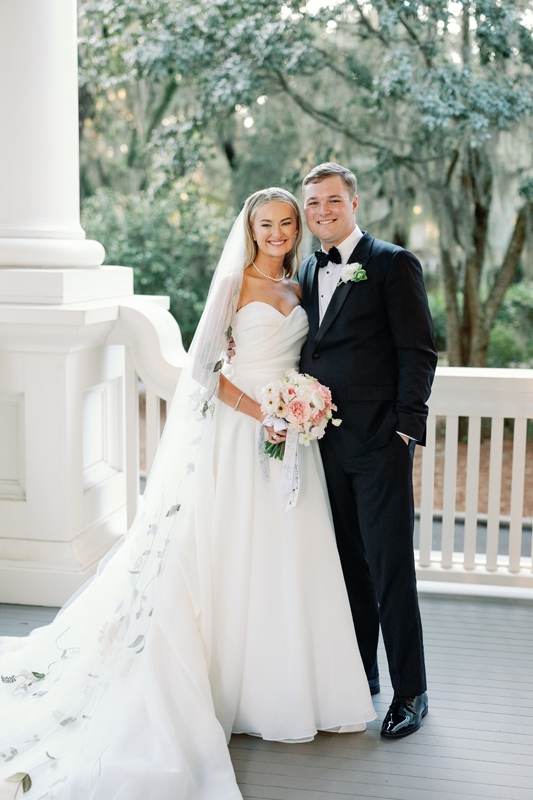 The bride’s embroidered veil inspired a floral motif that surfaced on her bouquet’s hand-painted ribbon, the invitation suite, and the custom dance floor.