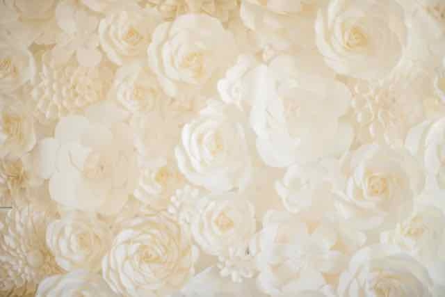 “A paper flower wall provides a stunning backdrop for the head table or lounge area, says Christina. “I’m building another one for a reception photobooth that will be staged behind a French settee. The flowers can be used again, or the panels can go into the couple’s home.”