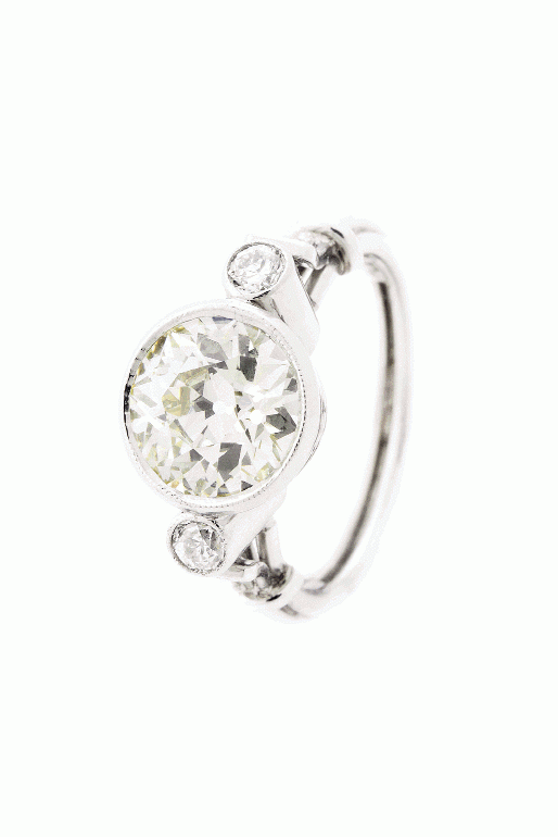 THREE TIMES THE CHARM:  Platinum ring with a 2.83 ct. center bezel-set round-cut diamond flanked by round-cut diamonds  (.29 total cts.) Joint Venture Estate Jewelers, $21,000