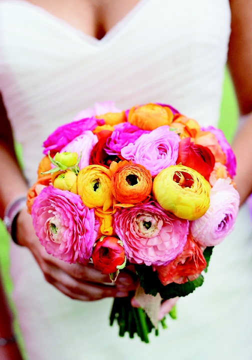 TO HAVE AND TO HOLD: Engaging Events’ floral designer Judy Johnston fashioned a cheerful bridal bouquet using the bride’s favorite flower, ranunculus, in a range of  hot colors from sunny yellow to fiery red.