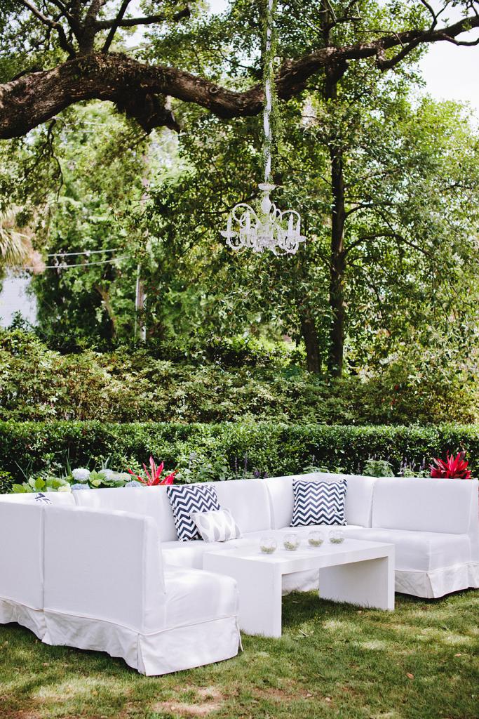 GARDEN PARTY: White sofas from Snyder Event Rentals were dressed up with chevron and ikat-patterned pillows. Loluma camouflaged chandelier chains with fabric and twisting vines.