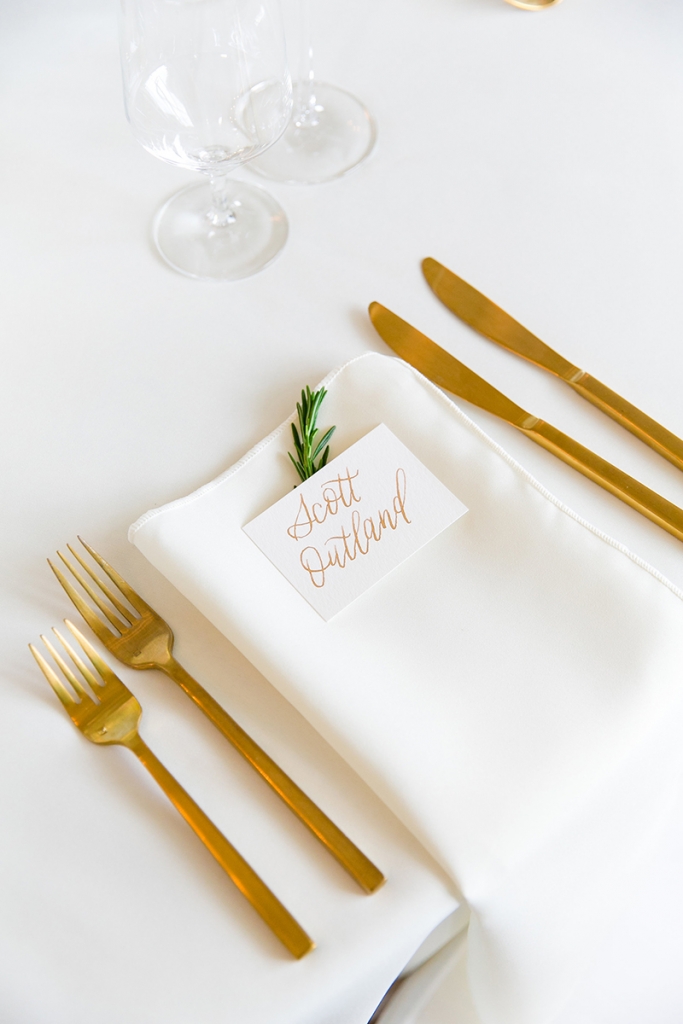 TIP: Stick with one calligrapher. Gold calligraphy (seen here on the invitations and place cards) is as ornate as it gets. Keep the look clean by using the same artist for multiple elements in the metallic hue.  Image by Dana Cubbage Weddings