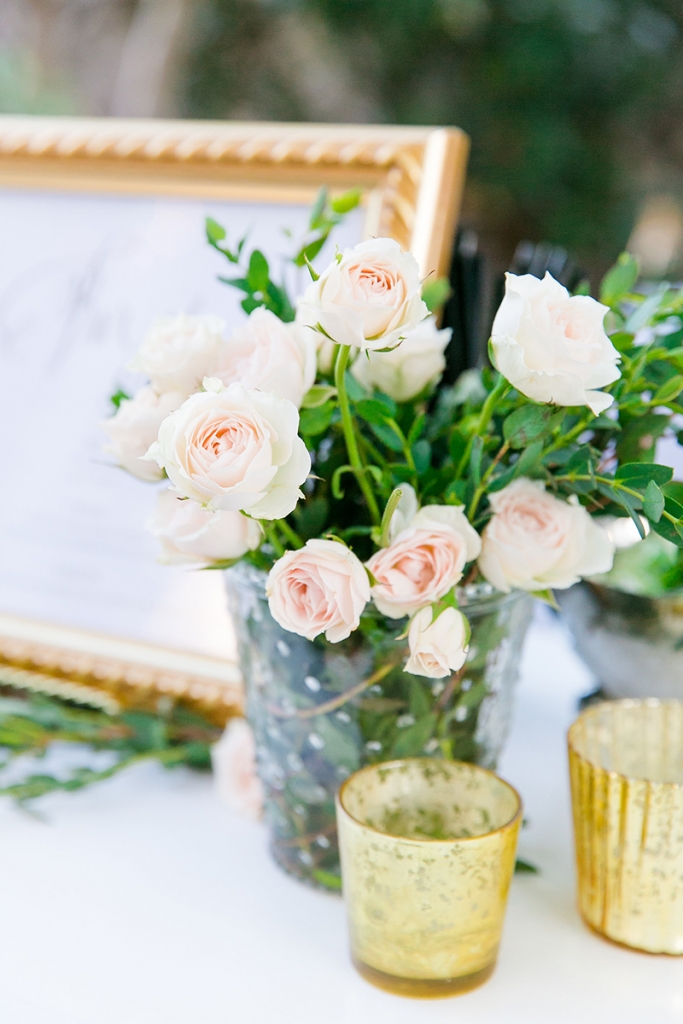 TIP: Pair shiny gold with shimmering crystal and mercury glass. Toasting flutes rimmed with gold, a glass cake stand with a hammered gold base, brass candelabras, and a collection of golden mercury glass-style vases echoed the subtle sparkle without overpowering the setting. Image by Dana Cubbage Weddings