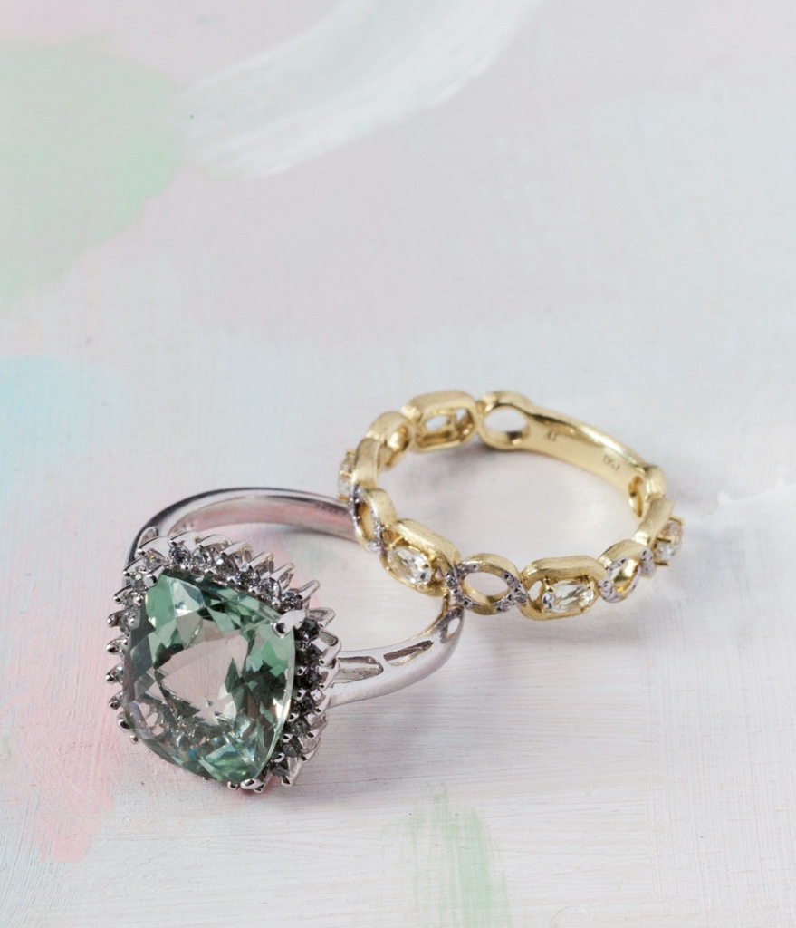 (from left) 14K white gold ring with 4.75 ct. green amethyst center and  diamonds (.26 total cts.) from Gold Creations, $1,100. Jude Frances’ 18K gold ring with .03 ct. diamond and white topaz accents from Croghan’s Jewel Box, $880. Artwork by Natalie Taylor Humphrey
