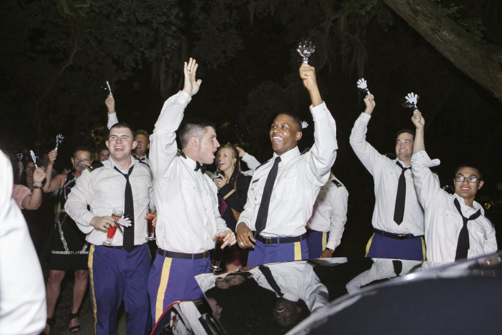 TEAM SPIRIT: Revelry met rivalry as Micah’s fellow West Point grads cheered the newlyweds on their way with custom “Go Army! Beat Navy!” clappers