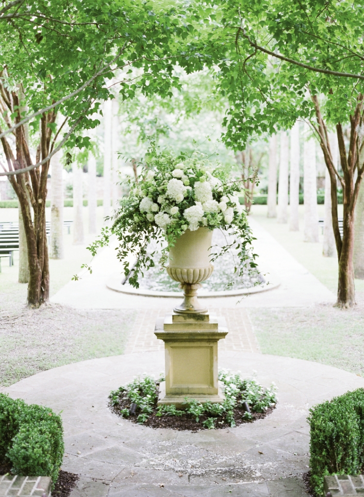 WARM WELCOME: Blossoms Events filled a cast-iron urn with copious garden roses, hydrangea, spirea, viburnum, and various greens for a verdant, natural look that melded with the estate’s plantings.