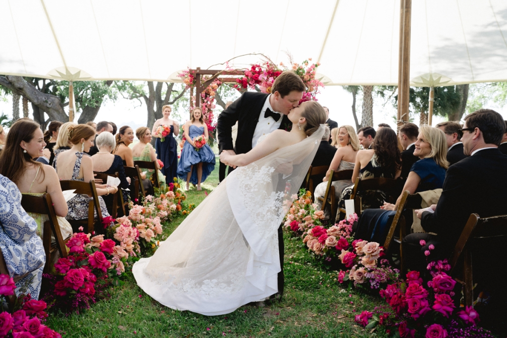 After dear friends from both sides of the aisle showered them with pink petals and best wishes, newlyweds Alex Rogers and Brooke Grice paused for a kiss during their flower-trimmed fête at Lowndes Grove.