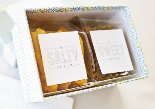 CRUNCH ‘N’ MUNCH: Welcome boxes filled with cheese straws from Hamby Catering were wrapped in cheery blue paper and hinted at the event’s colors.