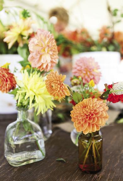 HAPPY HUES: Colorful dahlias tucked into vintage bottles softened the otherwise black and white palette.