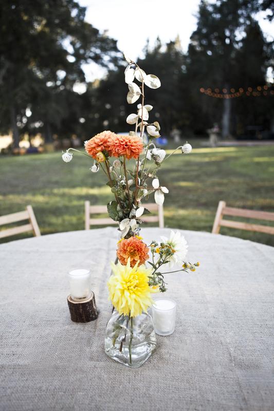 STUNNING SET: Burlap-covered tables were brightened by dahlias and accented with votive candles set at various heights.