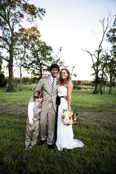 LOCAL THREADS: Ashley donned Callie Tein’s “Faye” gown from Modern Trousseau and a headband from Out of Hand. John and his son, Louin, wore suits from Berlin’s for Men.