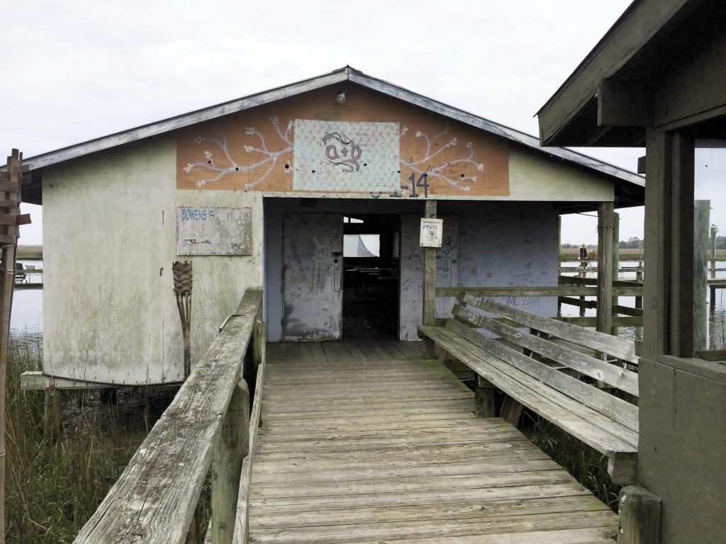 Before: The Bowens Island Dock House, was the one and only potential venue Amelia scouted. Given free rein to freshen up the space, she swept out years of shrimp and oyster shells, washed the windows, and painted the facade from a 10-foot ladder during low tide.   Image by Susan Dean Photography at Bowens Island Restaurant.