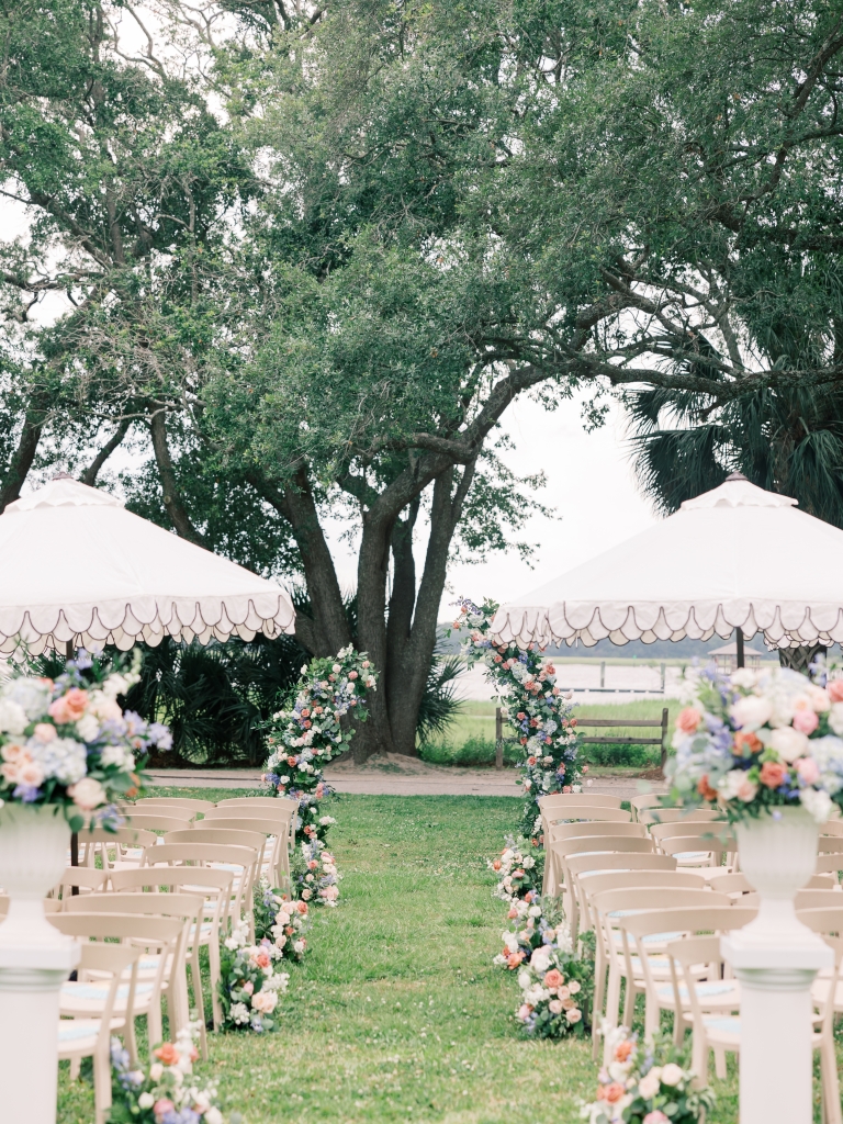 Local planner and designer Chelsye Harp, owner of Intrigue Events, maximized Lowndes Grove’s natural beauty for a client’s wedding by using the Ashley River as the backdrop for the ceremony, made even more special by a floral aisle and arbor by Forever Flowers Charleston.