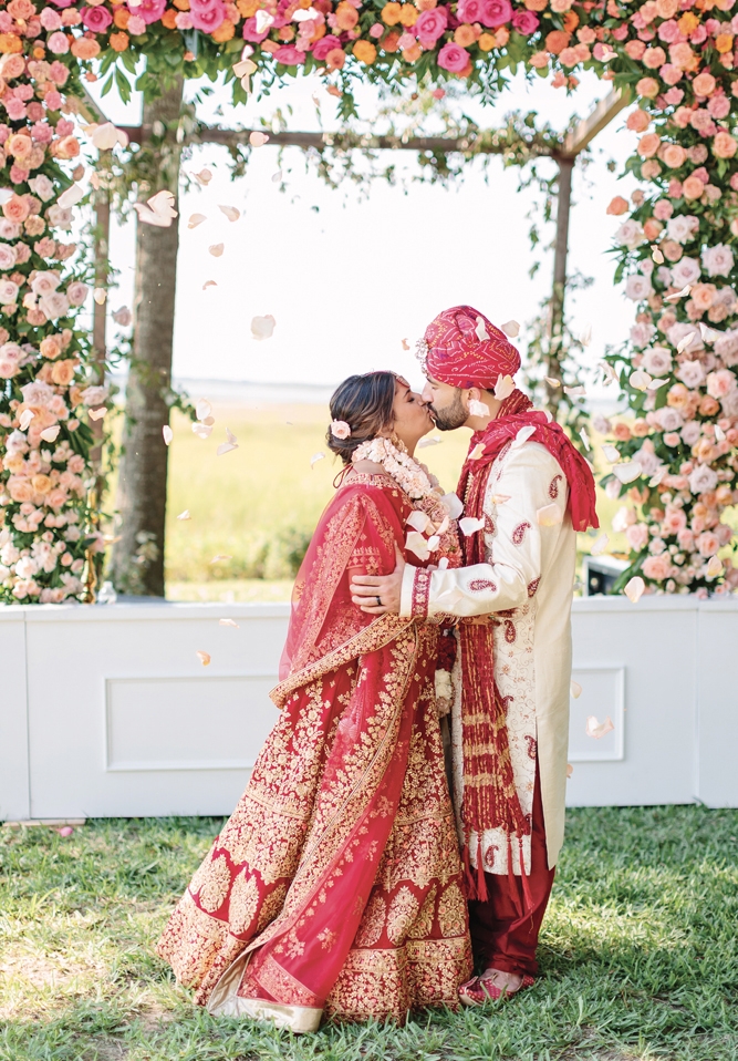 Adhering to tradition, Krish donned an Indian sherwani while Pooja wore a richly embroidered saffron red lengha, accessorized with mehndi body art and ornate jewelry, including the heirloom nose ring her mother had worn at her own wedding.