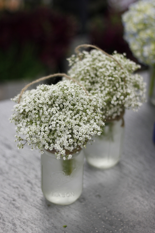 Baby&#039;s breath and Mason jar aisle markers give an airy, delicate feel while being rather inexpensive.
