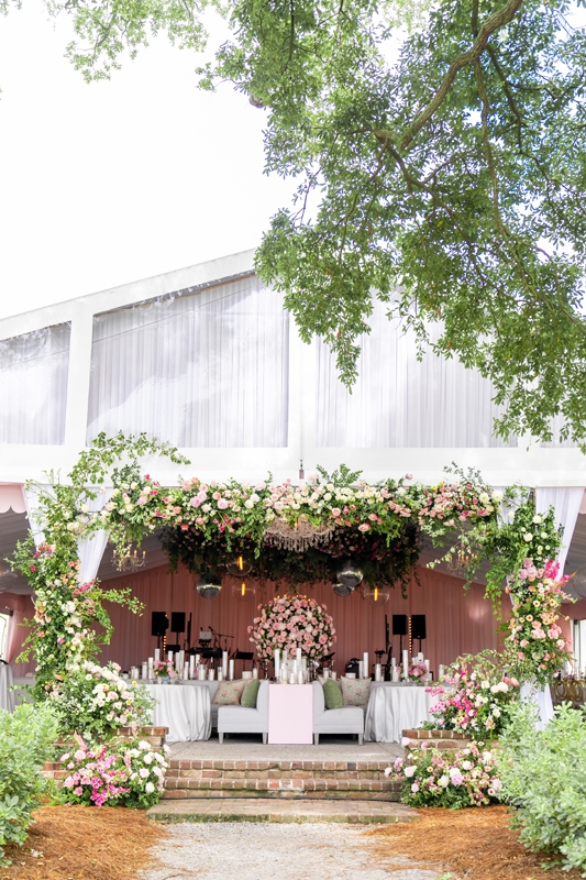 Extravagant floral arrangements by Blossom Bay set a dreamy scene inside the luxuriously draped tent.