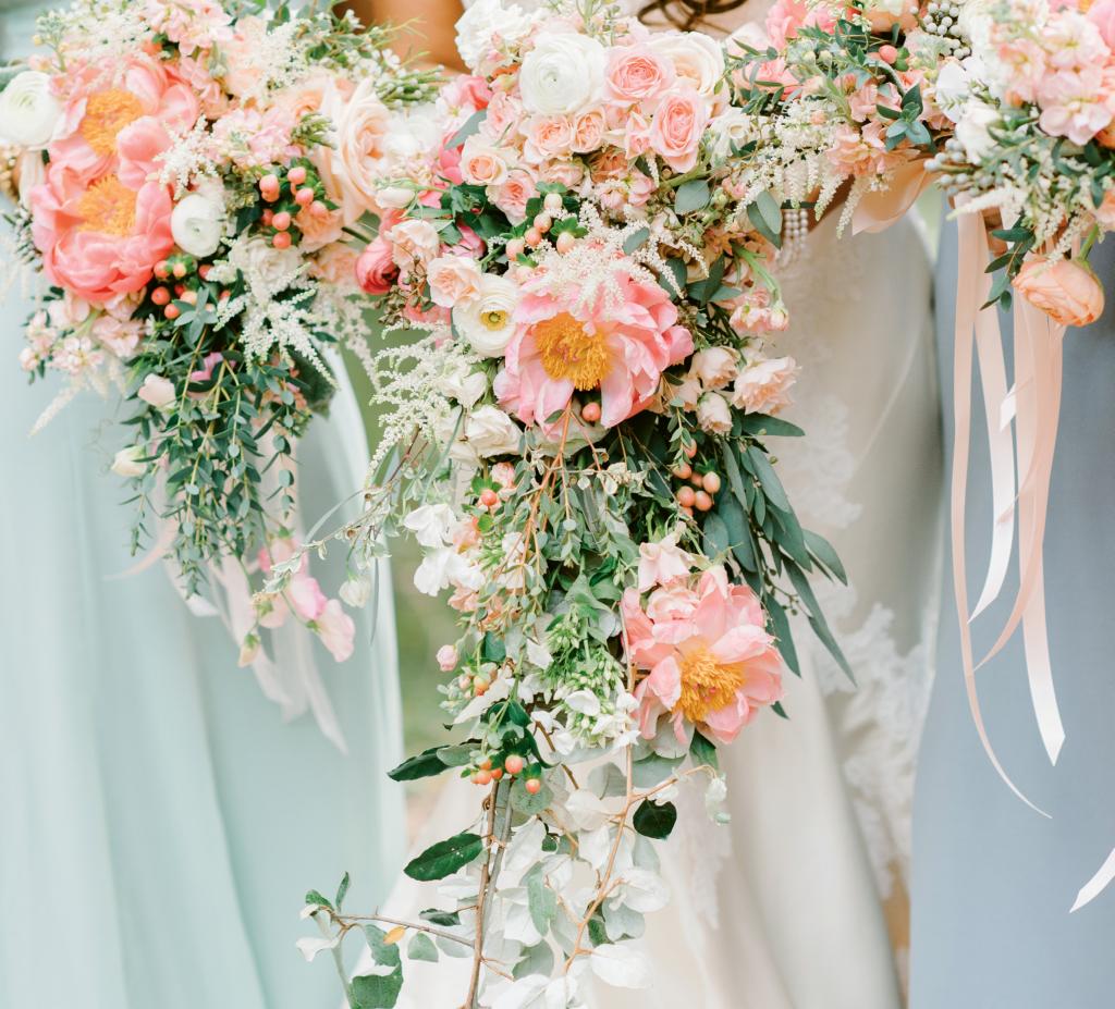 Bride Michelle Carlson opted for a cascading bouquet that almost swept the ground. Her maids of honors’ bouquets trailed slightly, and the rest of the attendants carried traditional blooms with trailing ribbons to balance the looks.