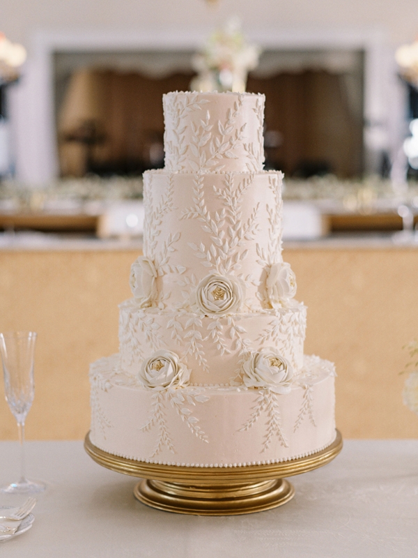 The barely-there pink wedding cake borrowed inspiration from applique flowers on Paige’s Mira Zwillinger dress.