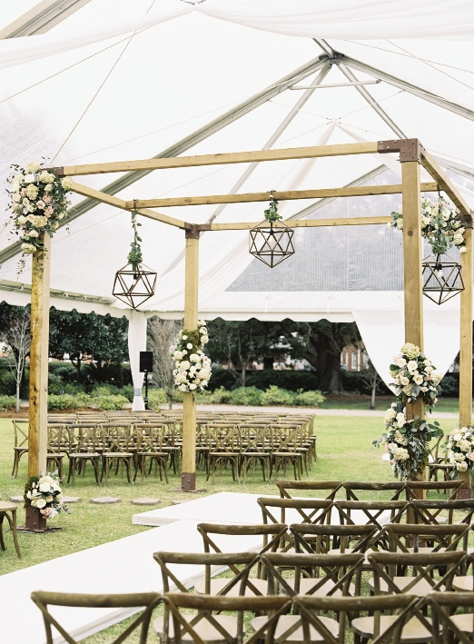 A clear-top tent protected the ceremony site and the custom timber frame altar when the day turned rainy. Laura says she would hang these lanterns throughout her house if there were room.  Rentals from Snyder Events. Lighting by EventHaus. Wedding design by A Charleston Bride. Image by Virgil Bunao Photography at Lowndes Grove Plantation.