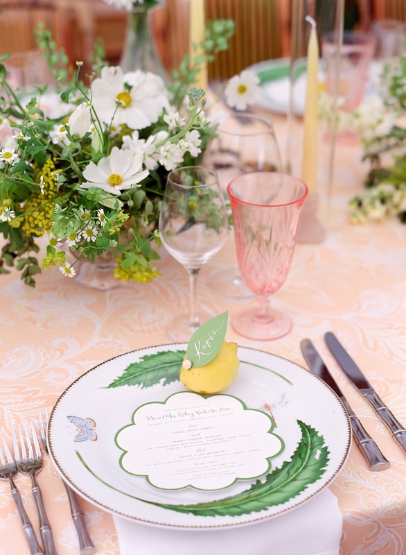 At Holly Fry and Keo Brown’s late May reception, wispy table arrangements, bamboo-style cutlery, and butterfly and citrus accents added pops of personality to the day’s garden party design.