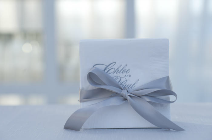 PAPER PRETTIES: Cocktail napkins bore the bride’s and groom’s names and matched the reception’s frosty palette