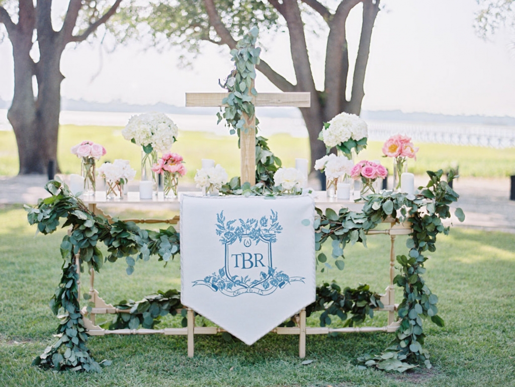 Wedding crest by Arabella June. Altar banner by Blossoms Events. Wedding and floral design by A Charleston Bride. Image by Ryan Ray Photography at Lowndes Grove Plantation.