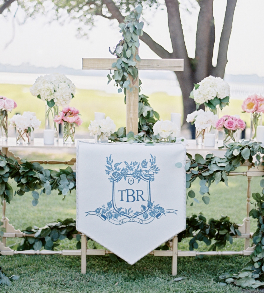 Charleston’s Boutique Tents re-interpreted a commissioned crest by Arabella June on this banner that was draped on the ceremony altar. The full-color version of the crest appeared on labels used in the welcome boxes each guest received. Image by Ryan Ray Photography