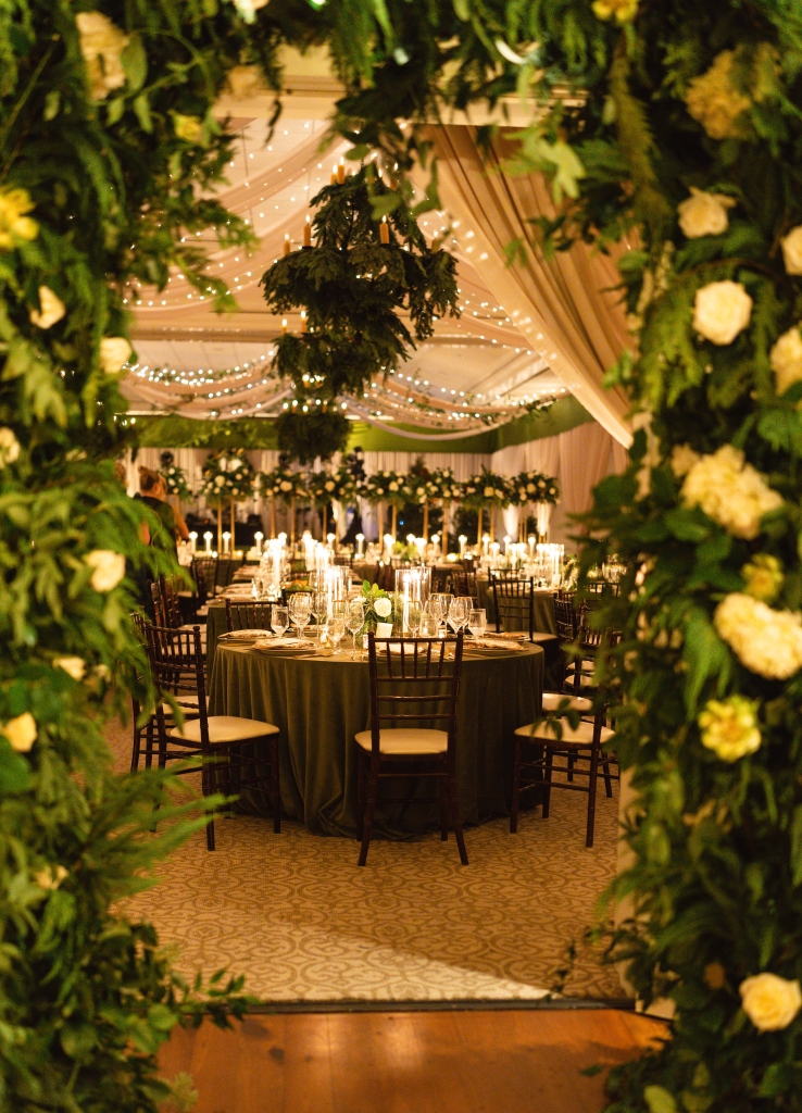 Swaths of champagne-colored draping, lofty evergreen arrangements, and soft candlelight transformed the Daniel Island Club ballroom into a cozy retreat for this December reception. (Opposite) Having vacationed here often as a girl, Carley Chimenti calls the Lowcountry her “happy place” and knew that Charleston would be the perfect location for her winter wedding to Robert Dilworth.