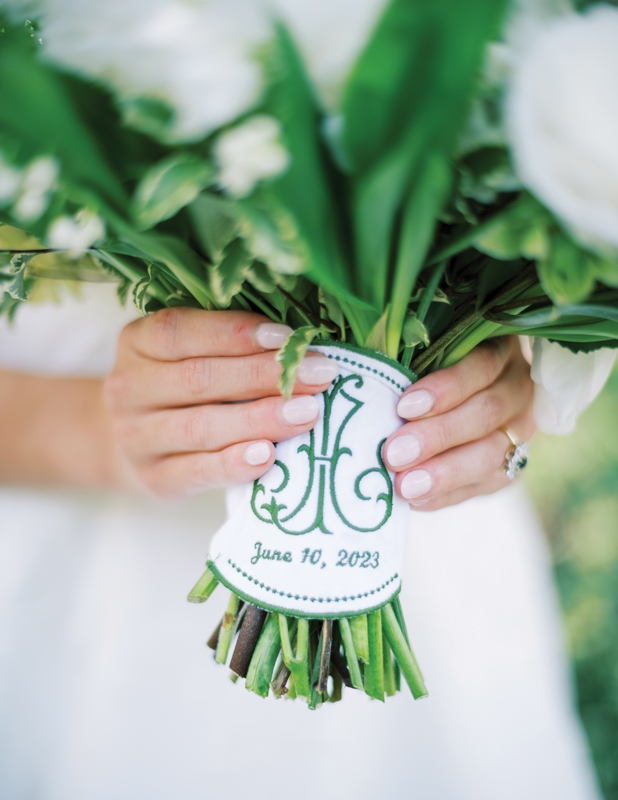 Ashleigh’s mom had the couple’s monogram and wedding date emblazoned on her bridal bouquet wrap in the same green hue used throughout the wedding.