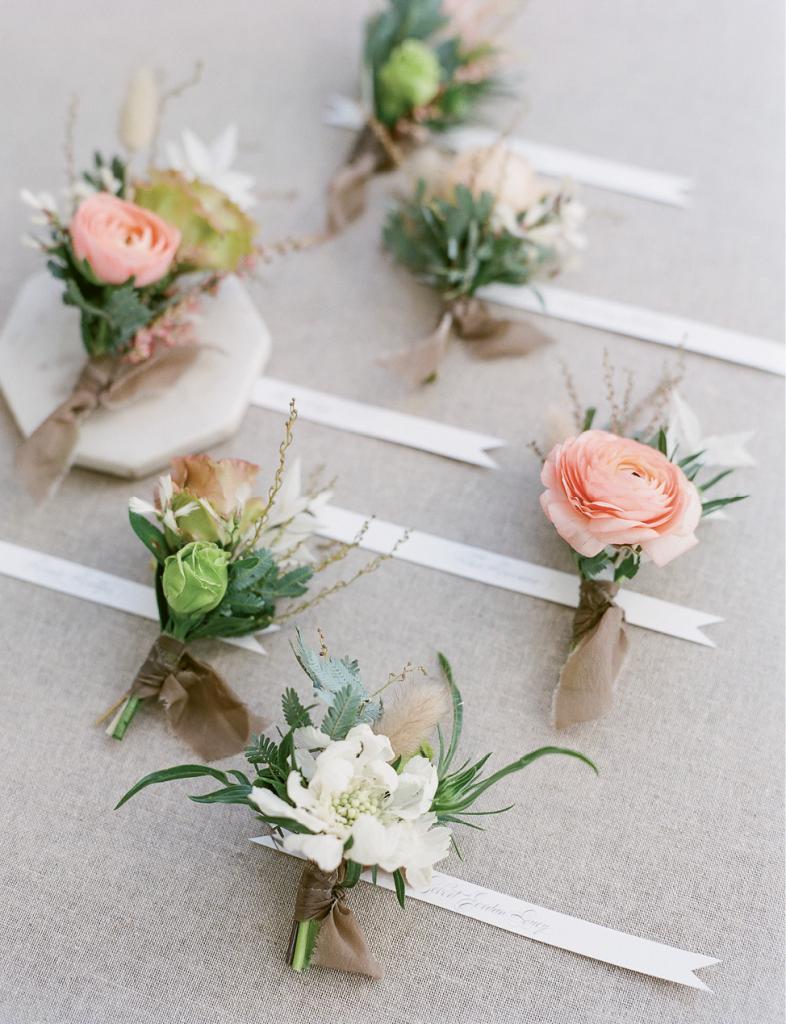 Finish boutonnieres with trailing raw silk that harkens the bridal bouquet ribbons.