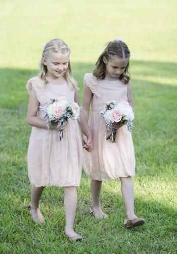 TREAD LIGHTLY: The flower girls carried bouquets that echoed the soft colors of their pale peach attire.