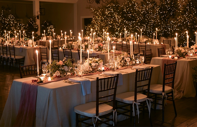 “We wanted to keep it elegant and softly romantic,” says bride (and interior designer) Lisette of why she and planner Alise skipped hurricane glasses on the tabletops. To generate an intimate, magical feel, they covered rented trees in the tiniest Christmas tree lights they could find. To cap off the ethereal styling, Alise hand-dyed muslin for runners and ran them across simple linen dropcloths.   &lt;i&gt;Photograph by Eric Kelley &lt;/i&gt;