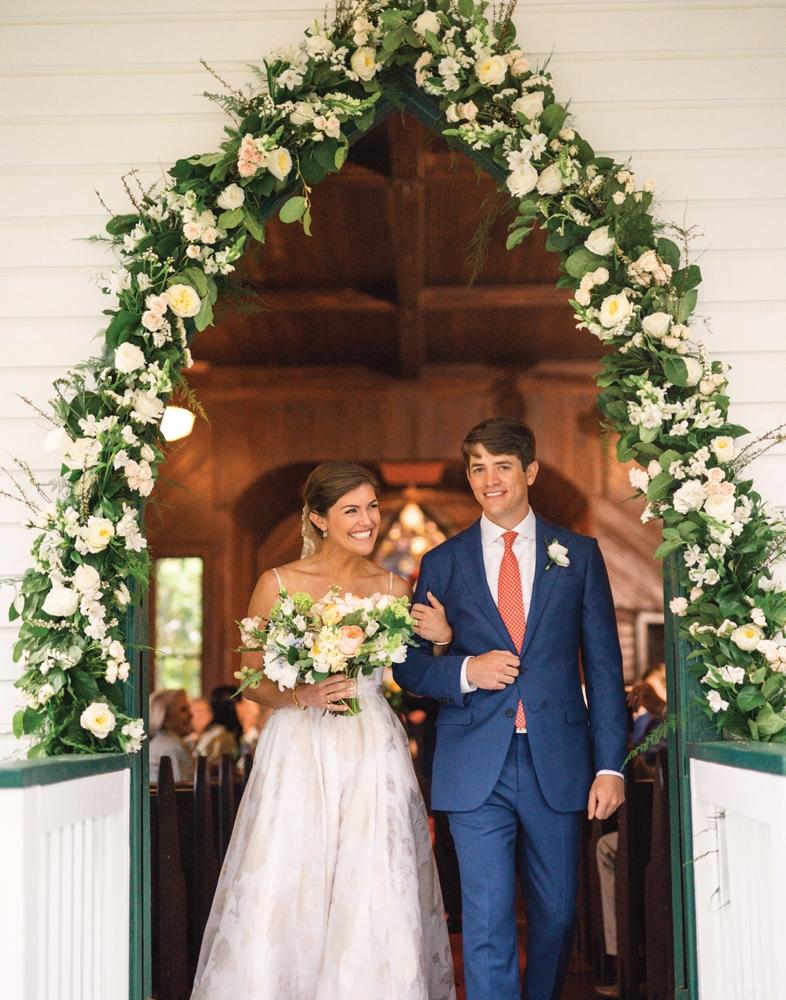 A garland with garden roses and greenery framed the chapel door.