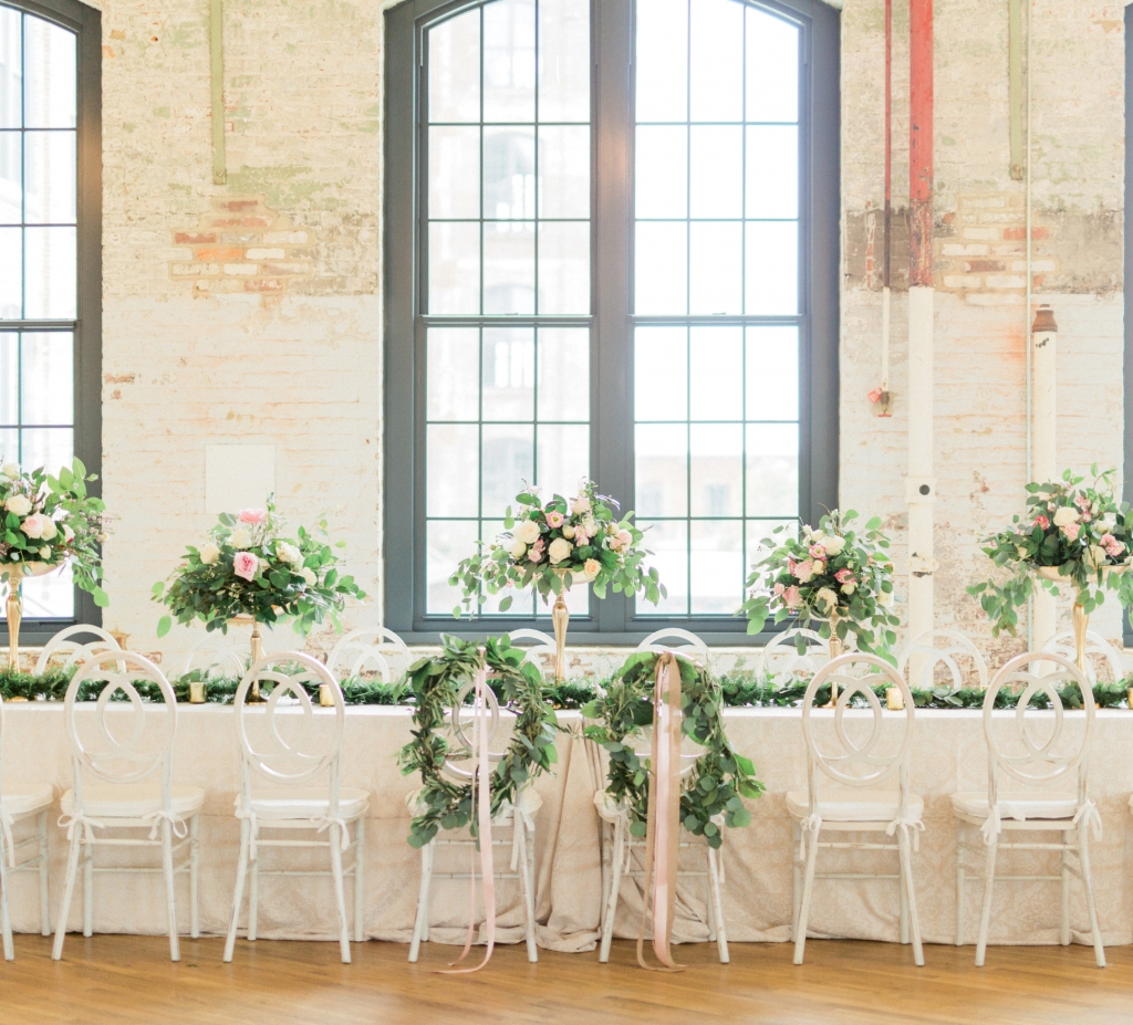 To soften The Cedar Room’s industrial aesthetic, Pure  Luxe Bride filled the space with verdant eucalyptus leaves, pillowy blooms, gilded vessels, and light, bright furnishings.   &lt;i&gt;Image by Catherine Ann Photography&lt;/i&gt;